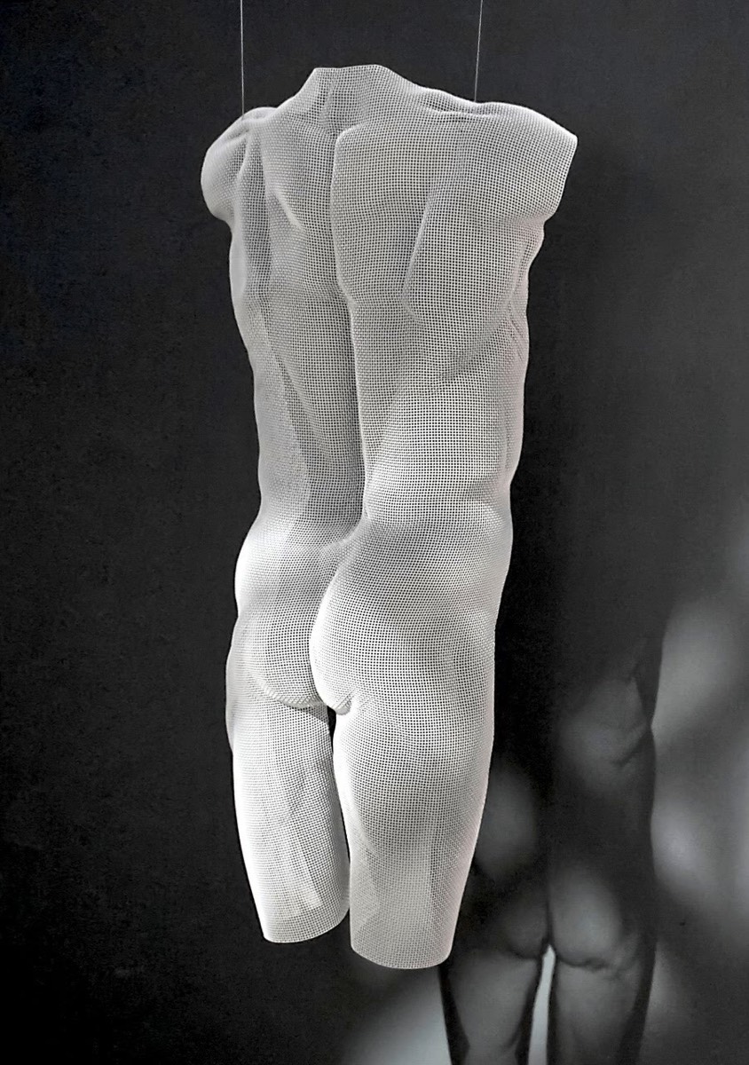 White suspended sculpture of a nude boy