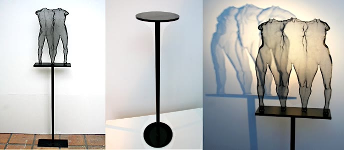 Three example of modern sculpture presented on a metal pedestal.