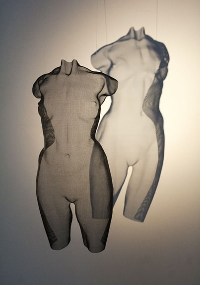 a hanging sculpture depicting a transparent torso