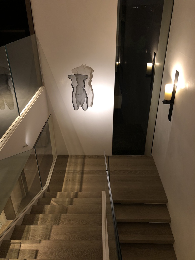 A modern wire sculpture dramatically lit at a staircase