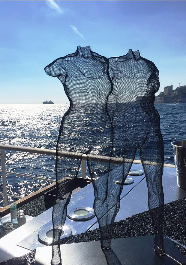 A transparent wire-art sculpture of two female figures seen on a yacht in Southern France