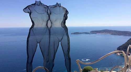 Two female figures in transparent wire-mesh with blue sea view near Monaco