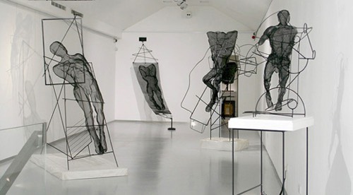 Male figures made of black wiremesh in a white exhibition showroom in london 2017