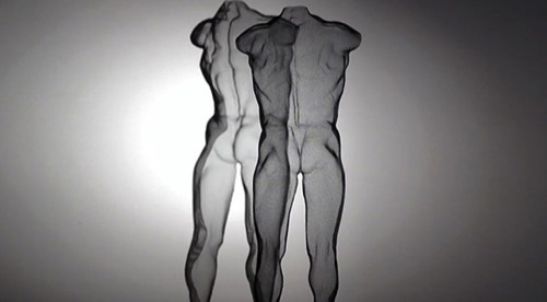 A nude male figure as a transparent wire sculpture with spotlight